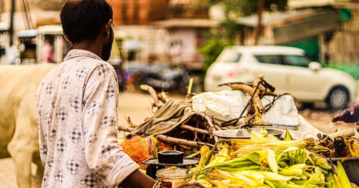 Small food stall owner preparing street food at a roadside counter