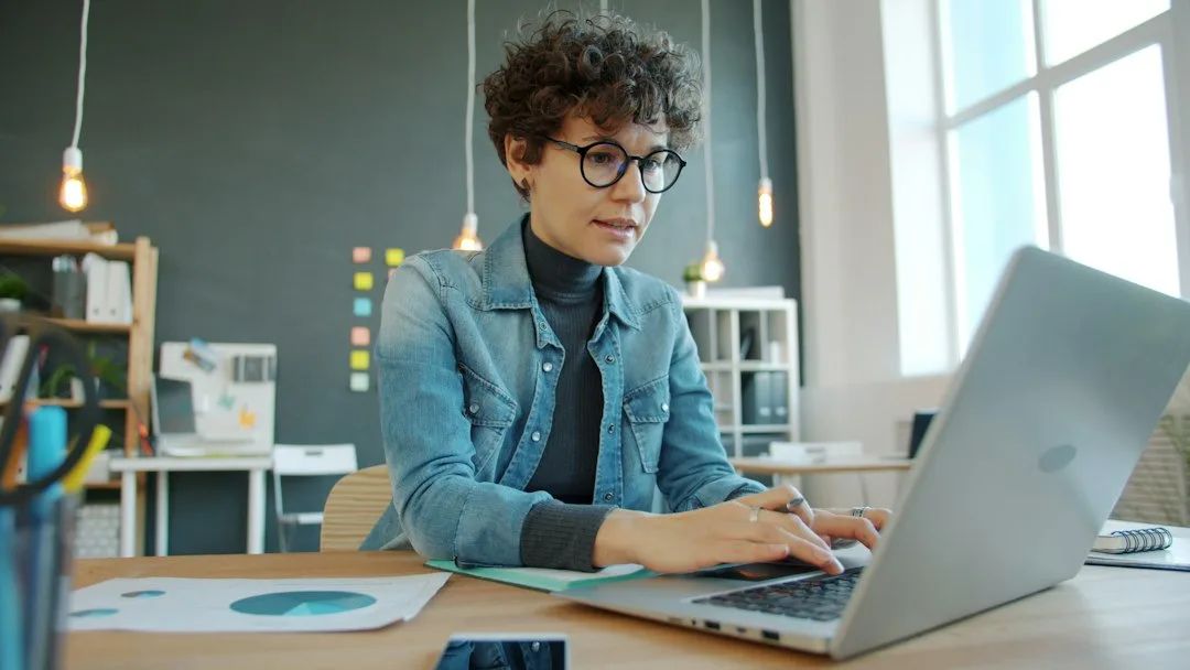 Business owner filling in an online trade licence application on a laptop in an office