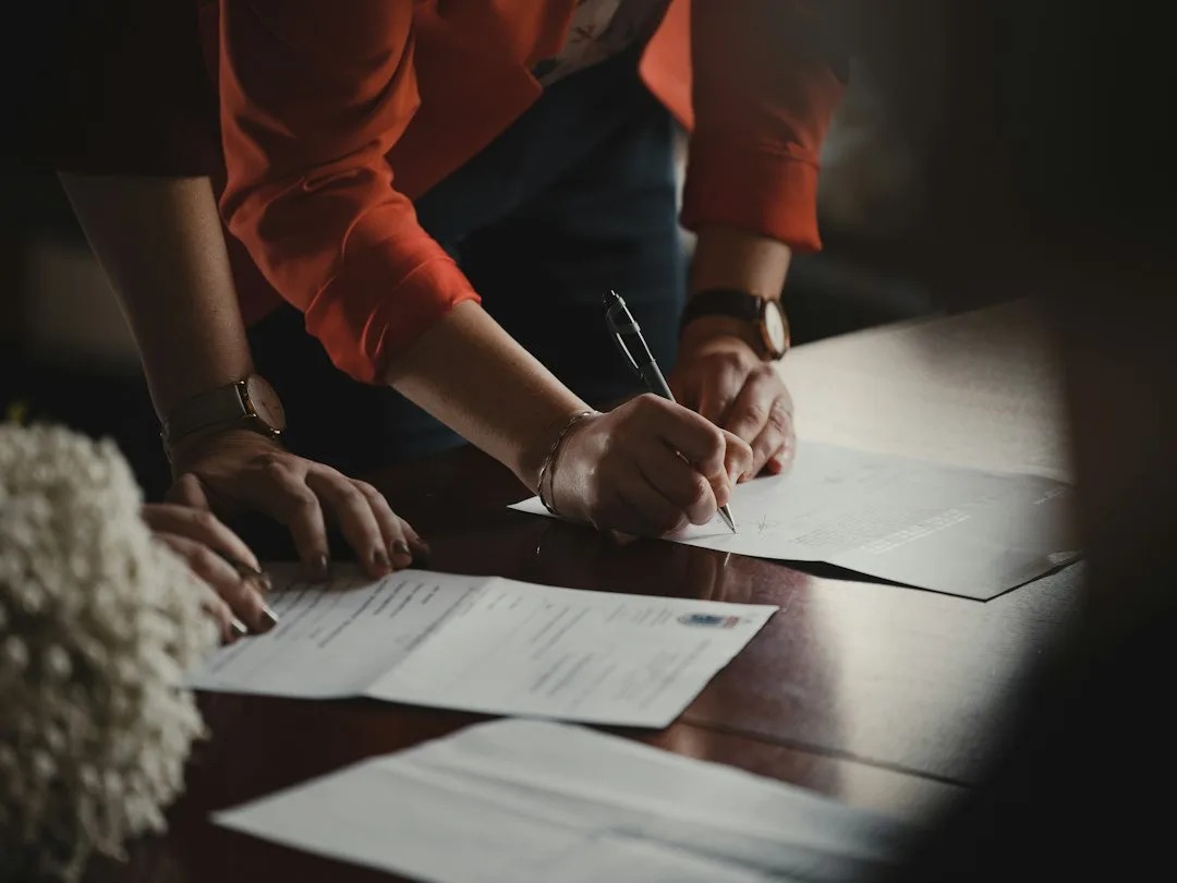 Professional hand signing a legal business agreement close up